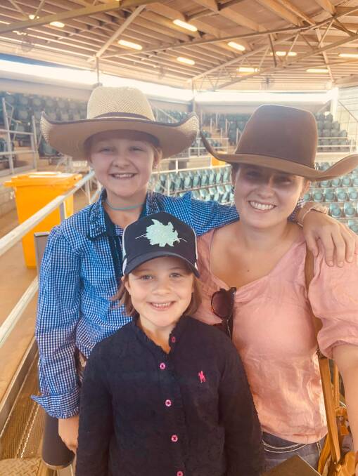 Kayla McIntyre taking Chelsea and Madalyn Collins out to the saleyards at Charters Towers. Picture: Contributed