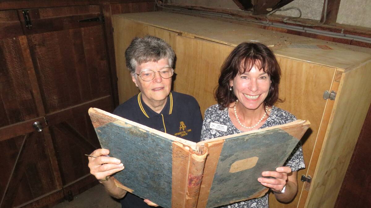 Herberton Mining Museum volunteer Mary Searston and Tablelands Cr Kate Eden with one of the old rating books. Photo David Anthony.