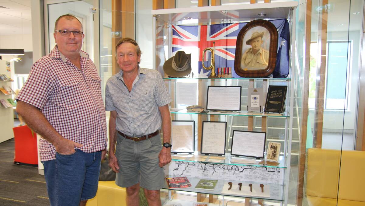 Innisfail brothers Andrew and Lew O'Farrell beside the public display of their late father Lewis O'Farrell's wartime memorabilia.