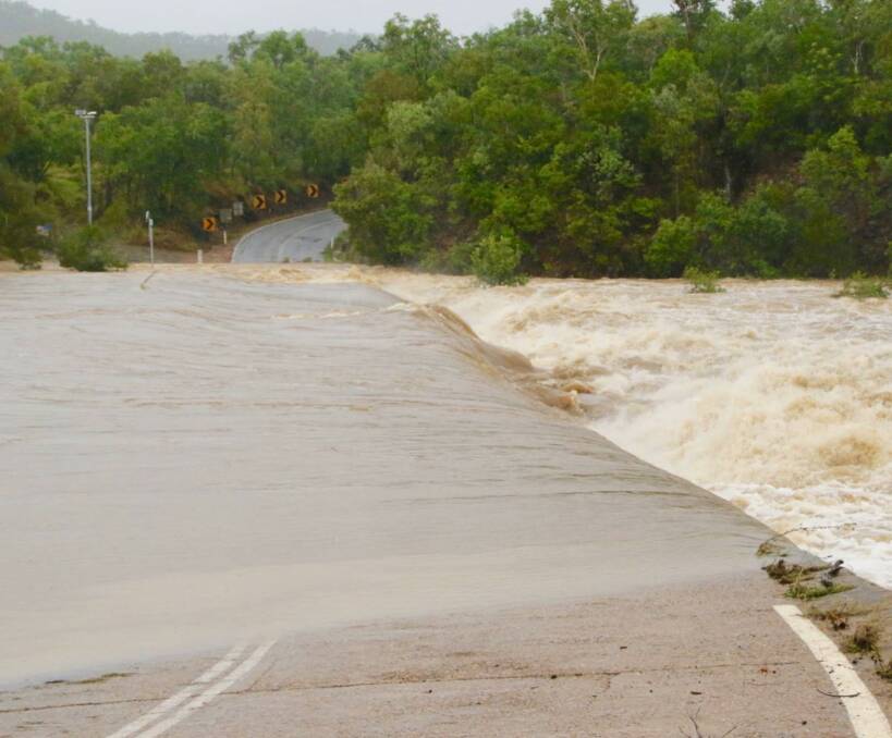 Rainfall bonanza: Cooktown resident Mary Brooks captured the Little Annan River near Cooktown flowing over the road at the weekend. The coastal community recorded its highest 24 hour May rainfall in nearly a century.