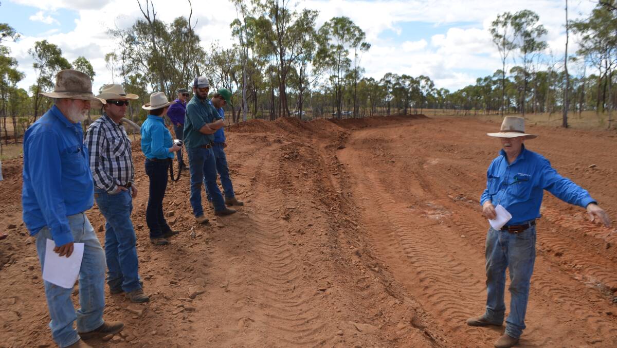 DAF principal extension officer Bob Shepherd explains to guests how this ridge adjacent to the gully has been turned into a channel which will spread rainfall over a wide area before safely entering a drainage line downstream of the gullied area.