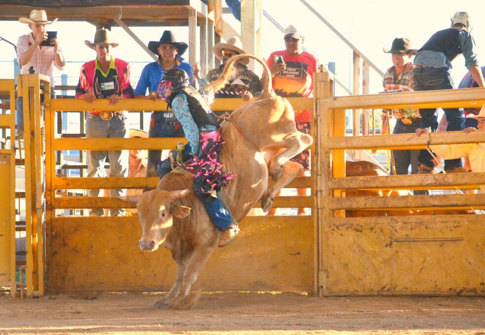 Tristan Braden holds on tight during the juvenile bull ride competition at the Qld & NT Indigenous Bull Riding Championships held at Charters Towers on Saturday.