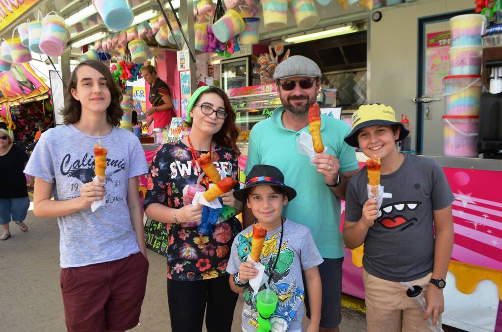 Enjoying the delight that only a dagwood dog can bring are Taylor Fleming, Brielle King, Malachi King, Jason King and Noah King who had a ball at the Townsville Show on Saturday.
