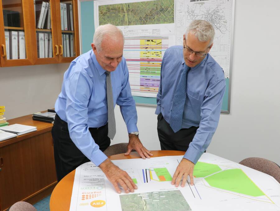 Development greenlight: Burdekin Mayor Bill Lowis and council’s Economic Development Manager Adrian Scott look over the plans for the Clare Solar Farm.