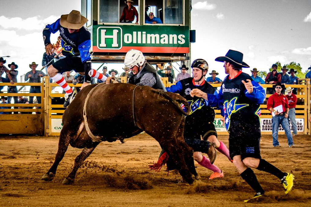 All in a days work: Protection clowns Bob Dahl (in the air), Robert Pemble and Brodie Land help out a hung up rider during the open bull ride. Photo: Mel Bethel Photography.