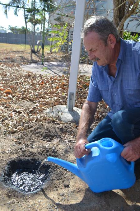 Steve Moir fills the test hole he dug at his home in Townsville to monitor how a polymer modified bitumen - which is currently used to seal roads against water seepage - could be engineered for increased water retention in dams.