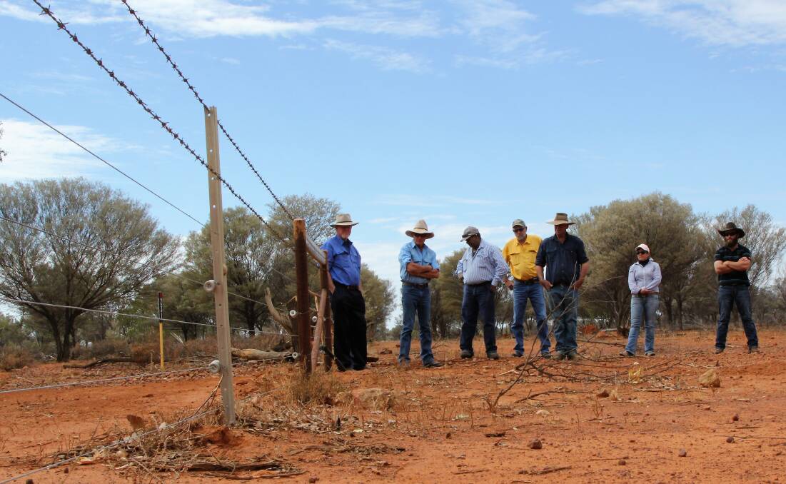 Field day attendees inspect the electric fencing installed to keep the goats in and wild dogs out.
