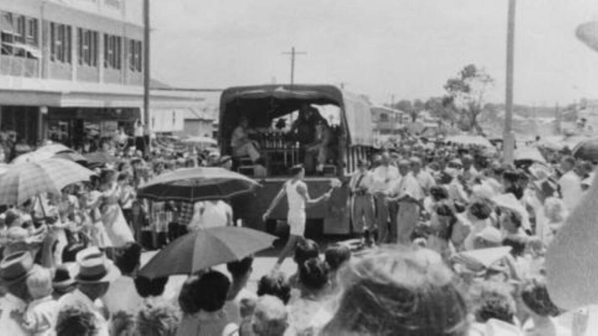 A 1956 Melbourne Olympics torch bearer running through the streets of Bowen. Photo sourced from John Oxley Library, State Library of Queensland.