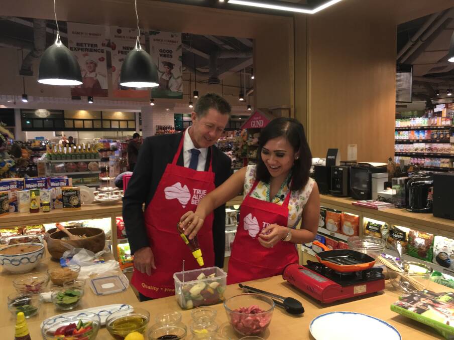 Assistant Minister to the Deputy Prime Minister Luke Hartsuyker at the Ranch Market supermarket, doing a cooking demonstration to promote Australian beef with Indonesian chef Wina Bissett - a promotional event by Meat & Livestock Australia.