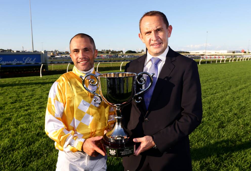 New Australian Racing Hall of Fame inductee trainer Chris Waller (right) celebrates with jockey Michael Walker after Comin' Through won the Hardy Brothers Doomben Cup on Saturday. Picture - Darren England 