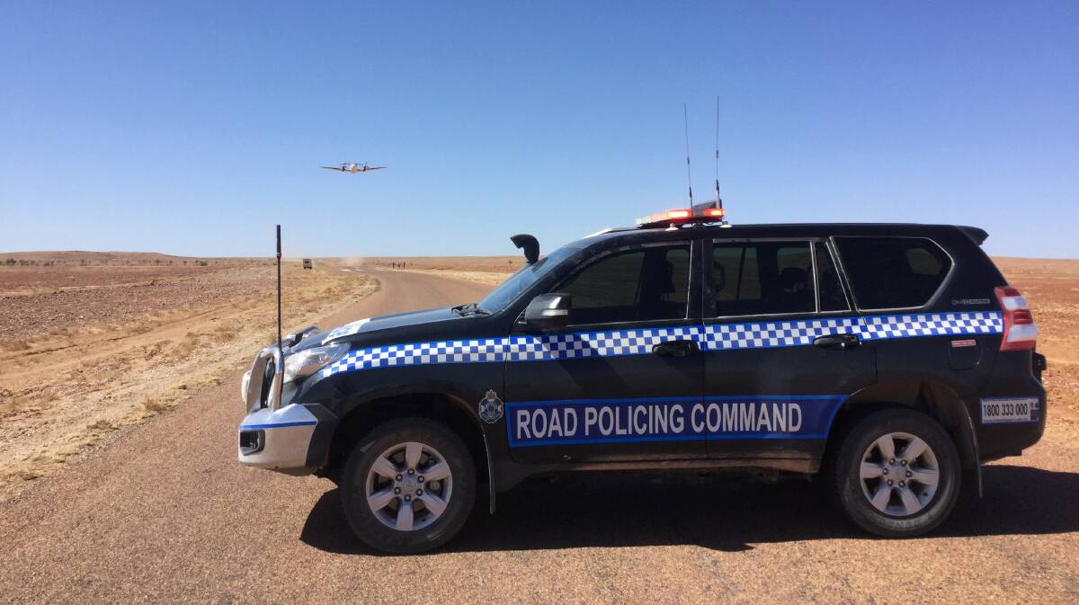 AIRSTRIP ONE: Police close off the Diamantina Development Rd near Birdsville so a Royal Flying Doctor Service plane can land and take off again. Photo: QPS