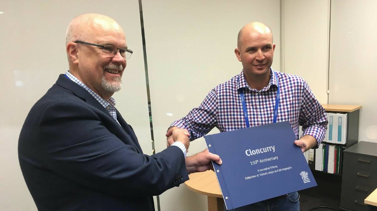 HISTORY: DNRM Valuer-General Neil Bray hands over the book to Cloncurry Mayor Greg Campbell at the LGAQ conference in Gladstone. Photo: supplied
 
