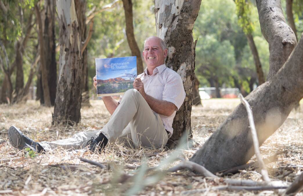 GOOD READ: Rawnsley Park Station owner Tony Smith, Hawker, relaxes with a copy of Pastoralism to Tourism - a book documenting the station's transition from grazing to tourism. The book was launched at the station on Friday.