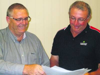 Wayne Thomas and Joseph Marano, chairman of Canegrowers Innisfail, look over the plans of the field day sites.