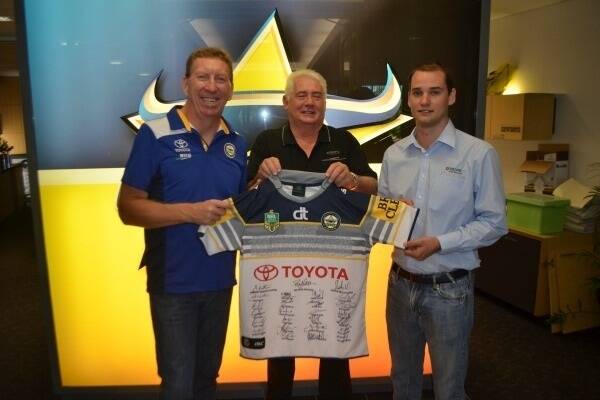 General Manager – Football for the North Queensland Cowboys Peter Parr with Tropic Petroleum’s Managing Director Jeff Regan and his son and CEO of the company Jamie Regan with the signed Cowboys jersey that will be auctioned off with all proceeds going to the Ilfracombe Scorpions.