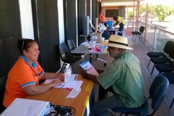 Apunipima Cape York Health Council Health Promotion Officer Priscilla Gibson talks to a resident about having his free health check at Hopevale.