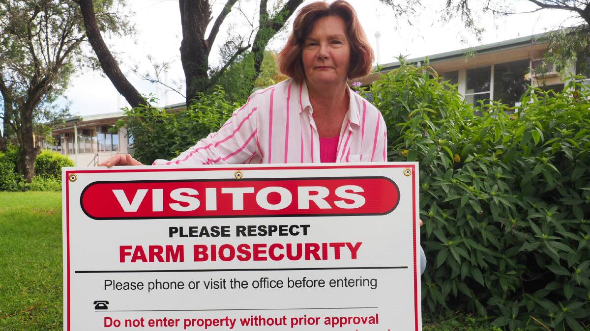 Grains Biosecurity officer Kym McIntyre with farm gate biosecurity sign available to farmers.