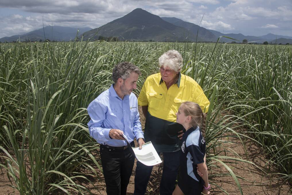 Canegrowers CEO Dan Galligan talking about the schools latest resource with Gordonvale cane grower John Ferrando and his granddaughter Sofie, 9.