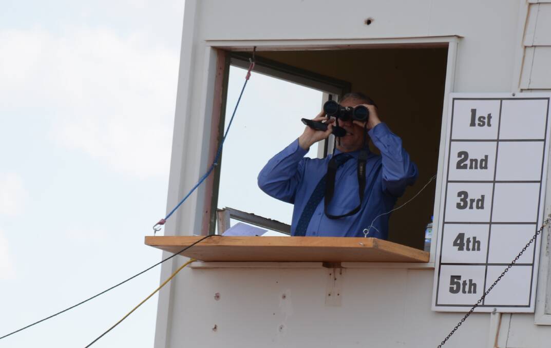 Racecaller James Coghlan keeps an eye on the positioning on the track. 