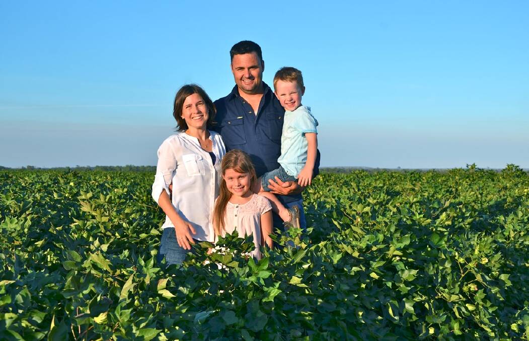 Emerald cotton growers Nigel and Beth Burnett and Millie, 7, and Lachlan, 4, in their cotton on their property, Colorada. The Burnetts will start harvesting next month.