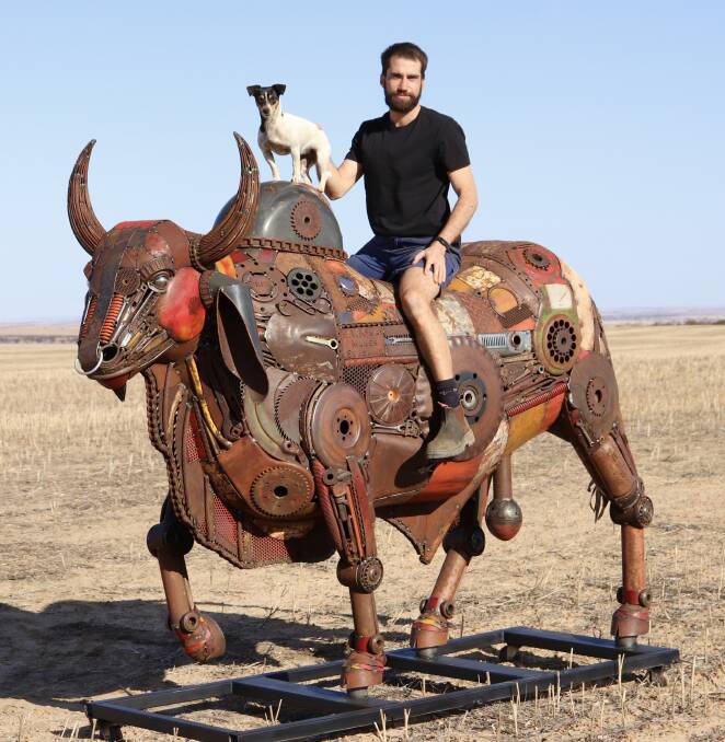 Jordan Sprigg and his dog Molly on top of his Brahman Bull sculpture. The sculpture was privately commissioned for a customer in New South Wales and took 350 hours to make.