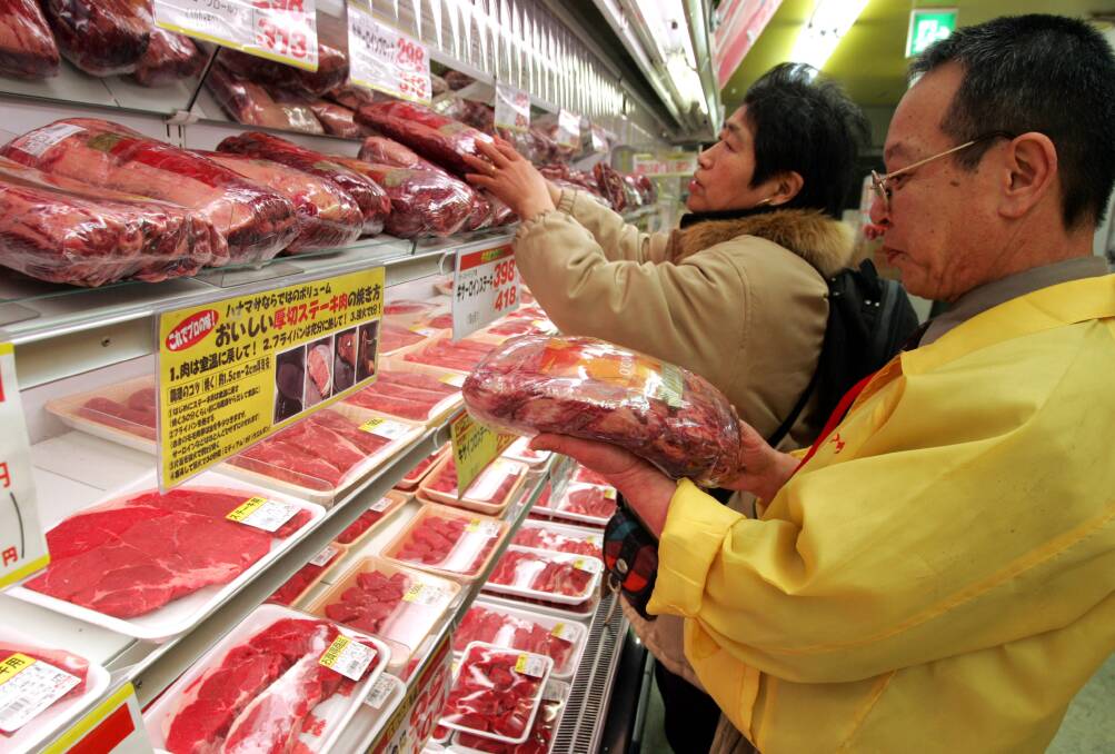 
A sales manager at Hanamasa meat wholesale chain helps a customer choose a chunk of Australian beef in Tokyo. 