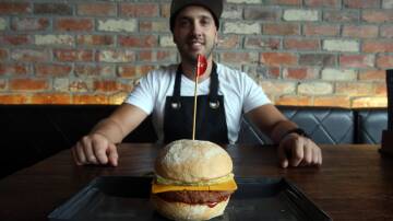 ON THE MENU: Grill'd Wollongong manager Allen Markovski with a vegan cheese burger. Picture: Robert Peet
