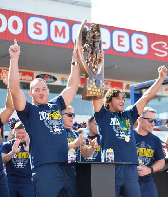 Pure joy: North Queensland Cowboys co-skippers Matt Scott and Johnathan Thurston hold the Provan-Summons trophy high while receiving a rapturous reception from thousands of fans in Townsville on Monday. 