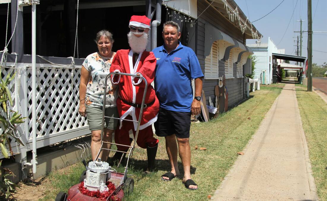 Chris and Dale Bignell give the lawnmowing Santa at the Golden West Hotel a push.