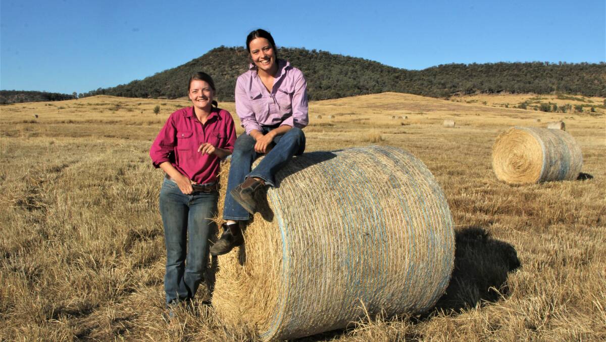 Bailed out: Ana Benham, right, and her sister-in-law Trine Jakobsen baling buffel grass hay at Tralee, east of Blackall. Picture: Sally Gall.