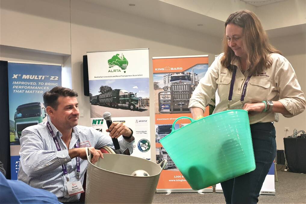 LRTAQ president Gerard Johnson helps Mary O'Brien demonstrate the importance of emptying your mental bucket and unwinding at the Livestock and Rural Transporters Association of Queensland conference at Roma.