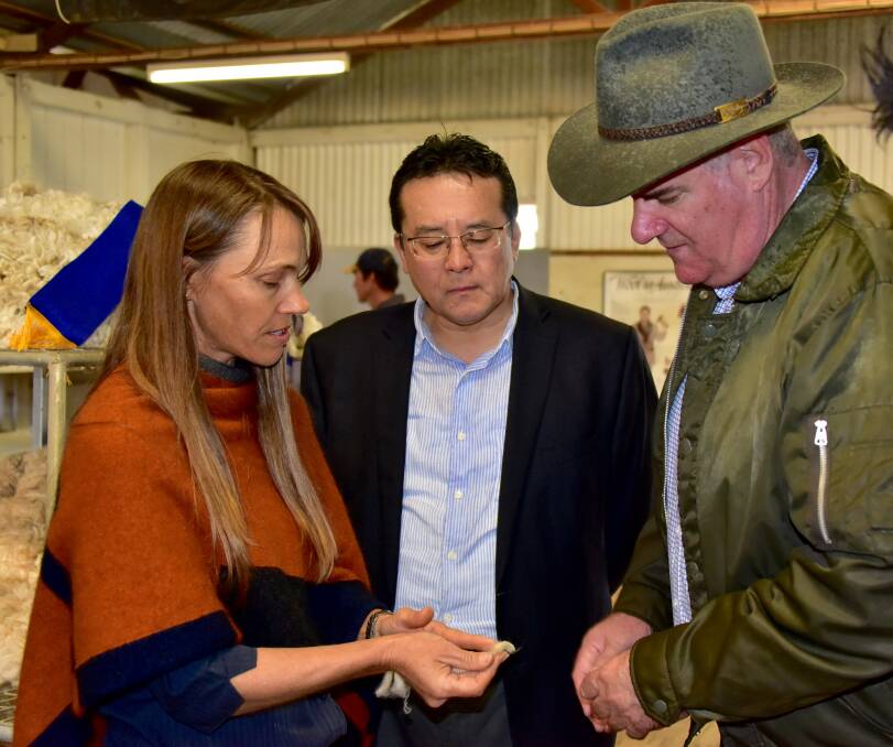 Winton wool grower Jodie Axford, Japanese Consul-General to Queensland Kazunari Tanaka and Agriculture Minister Mark Furner inspecting a nutrition-affected fleece at the Winton Show. Photo supplied.