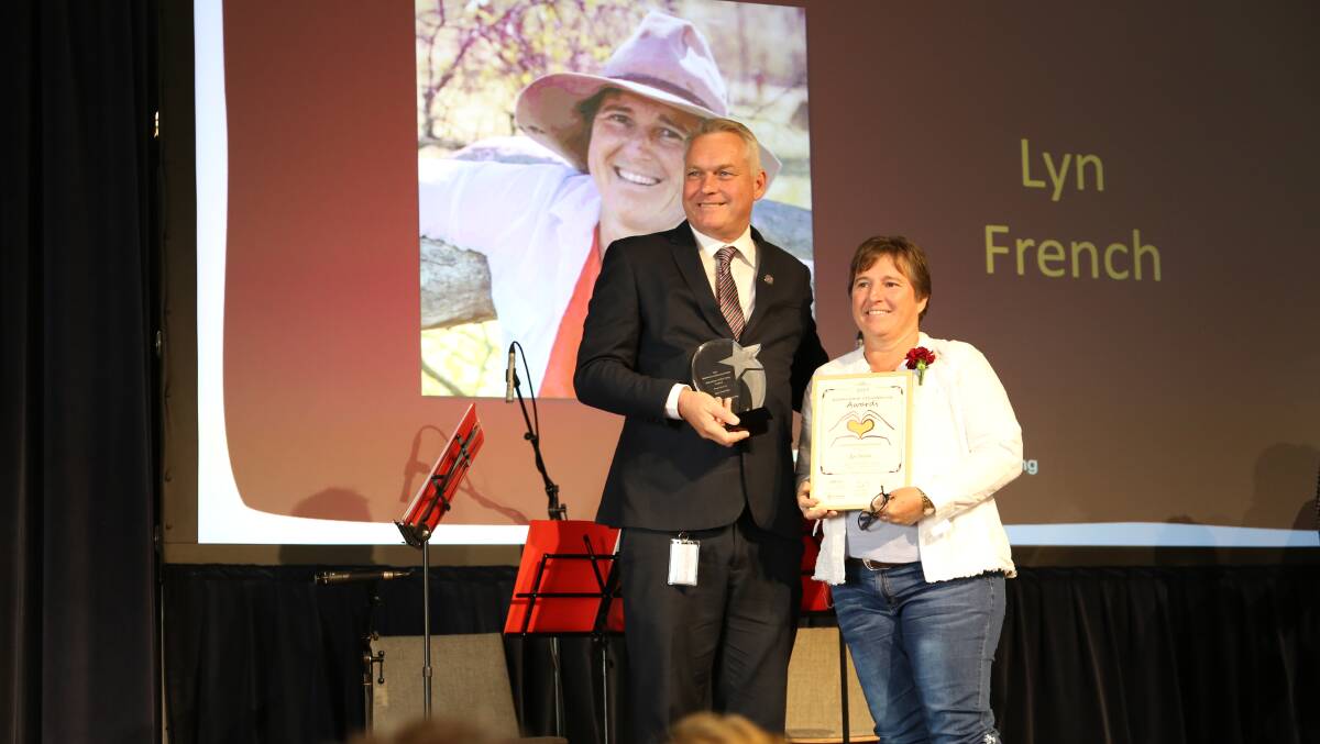 Lyn French being presented with the Volunteer of the Year award by opposition spokesman for volunteers, Lachlan Millar. Pictures supplied.
