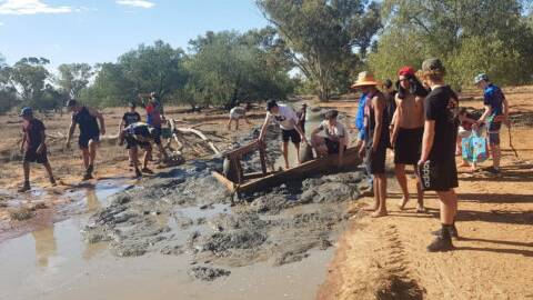 A group of students from Toowoomba staying with PLO Osborne clear out a bore drain to collect yabbies.
