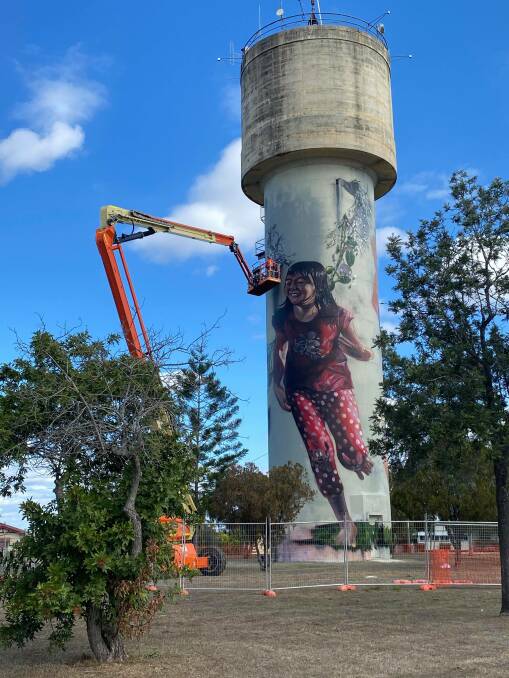 Six metre high children play among the artwork puddles on Monto's water tower.