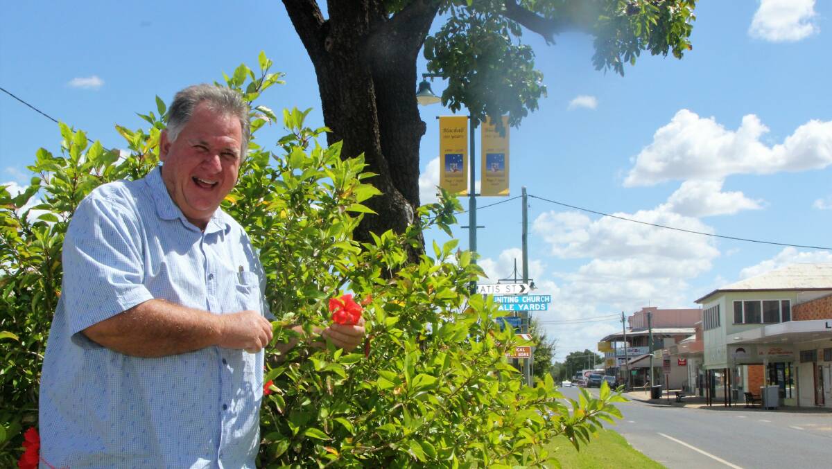 The pretty red hibiscus plant that's unique to Blackall, shown off by its discoverer, Neil Fisher.