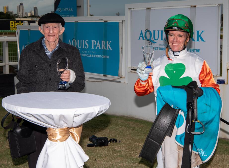 Veteran Toowoomba trainer Barry Squair with bandaged wrist and jockey Mark du Plessis display their trophies after 4YO mare Love You Lucy won the Gold Coast Silk Stocking. Squair injured his wrist when Love You Lucy dumped him at trackwork at Toowoomba recently. Picture: Racing Queensland
