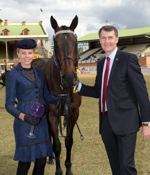Former Brisbane Lord Mayor Graham Quirk decorates the winner of the best presented horse and handler Rim Of Fire paraded by Renee Simpson, Innisfail during Thoroughbred judging at the 2014 Brisbane Royal Show.