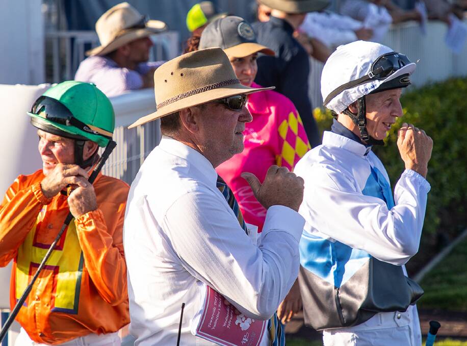 North Queensland chief steward Paul Gillard in the midst of jockeys in Townsville saddling ring. Picture: Mike Mills
