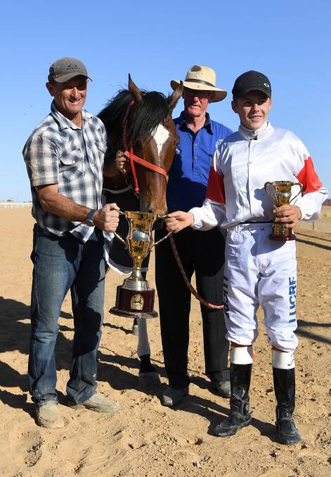 Jockey Adin Thompson (right) and trainer Bevan Johnson (left) celebrate winning the Birdsville Cup Open Handicap, with Blue Jest on Saturday. (AAP Image/Dan Peled) 