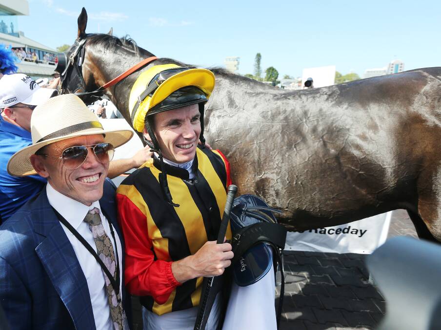 Jockey Tim Clark (right) and trainer Chris Munce after Boomsara won the Gold Coast $2M Magic Millions 3YO Guineas, during Gold Coast Magic Millions Race Day on Saturday. (AAP Image/Jono Searle)