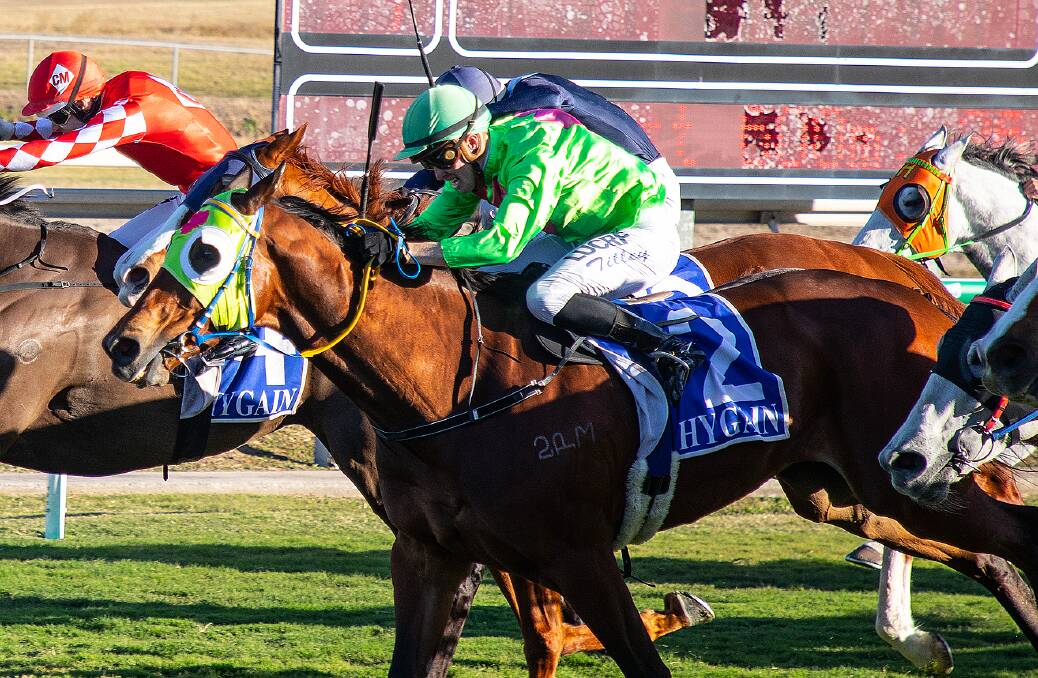 Rockhampton sprinter Mr Attitude ridden by Les Tilley (green colours) surges to win Townsvilles premier sprint, the Cleveland Bay Handicap. Picture: Mike Mills