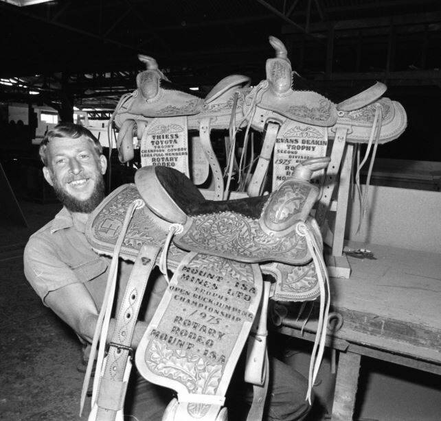 Memento: Donny Cummins showcasing the winners' trophy saddles for Mount Isa Rodeo of 1975. Photo: Supplied
