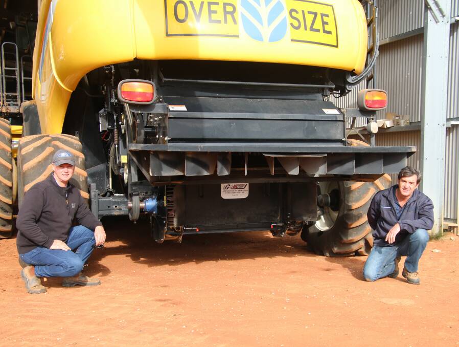 EXTERMINATE: Riverina grower Andrew Alexander, Boree Creek, and Geoff Anderson, McIntosh Distribution, discuss the performance of the new vertical, mechanical Harrington Seed Destructor fitted to the Alexanders' New Holland CR9080 harvester. 