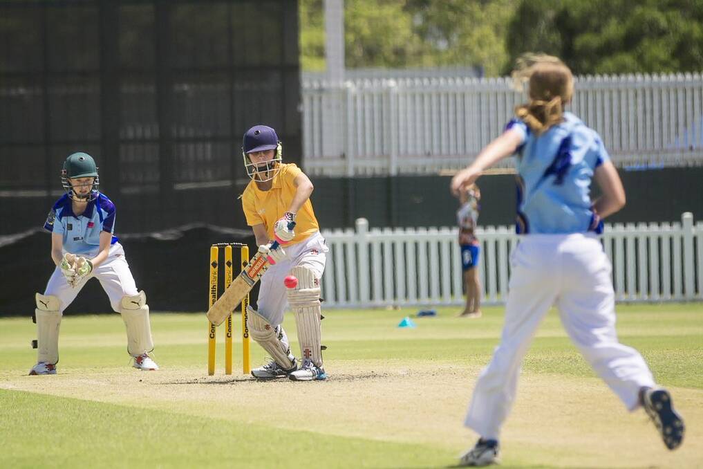 Becky Dwyer wicketkeeping (Hurricanes), Chelsea Williams batting (Central Highlands), and Meg McCartney bowling ( Hurricanes) at JJ Trophy IV tournament. 