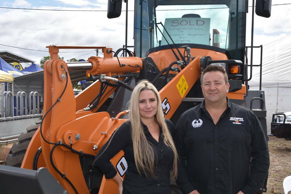 TRACTORS GALORE: Jasmine Ripia and Simon Collins, Olympus Loaders, Brisbane, at the Emerald Ag-Grow Field Days, pictured with an 11 tonne Wheel Loader YX636 which sold to an Alpha operation.
