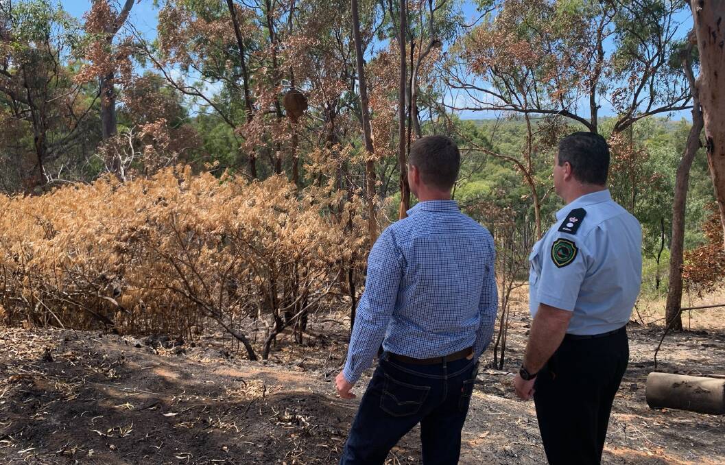 Emu Park landowner Peter Donaghy and Rural Fire Service Queensland central region manager Brian Smith inspect the site of a recent hazard reduction burn.