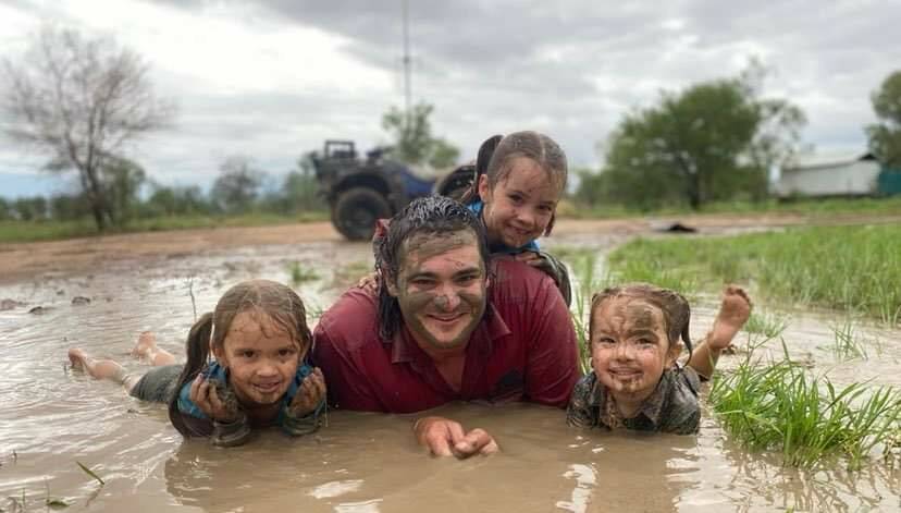 Heavens open up: Ashleigh, 5, Lucy, 6, Dakota, 2, with their dad Jake Carrington, after their property received 115mm since Monday. Photo: Samara Carrington 