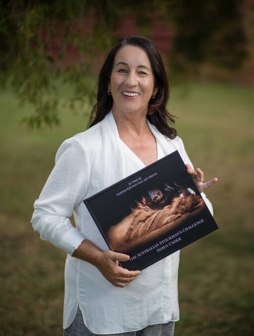 Photographer Jo Thieme holds up her new book 'The Australian Stockman's Challenge Down Under'. Photo supplied.