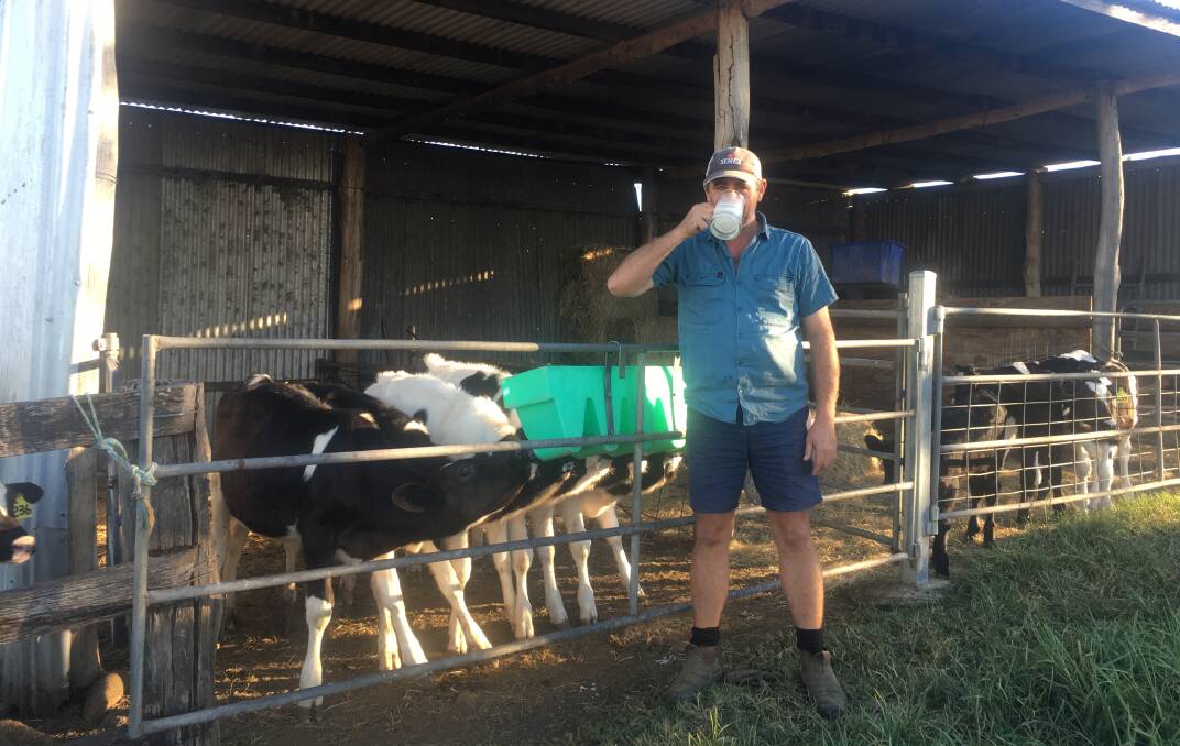 Rodney Teese having a drink with the calves on the farm.